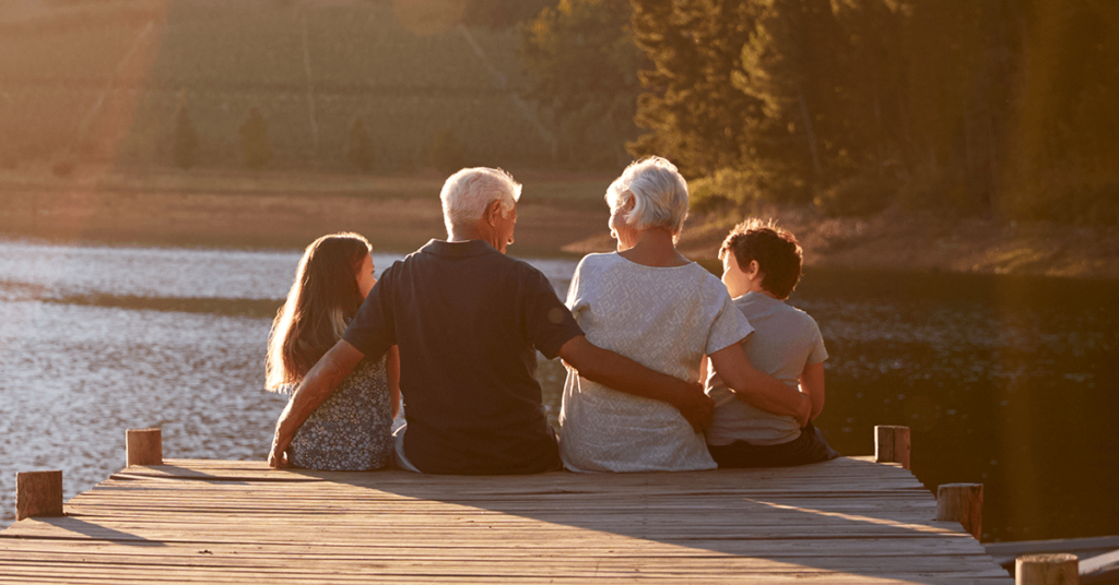 ahorrar para jubilación abuelos con nietos en lago atardecer